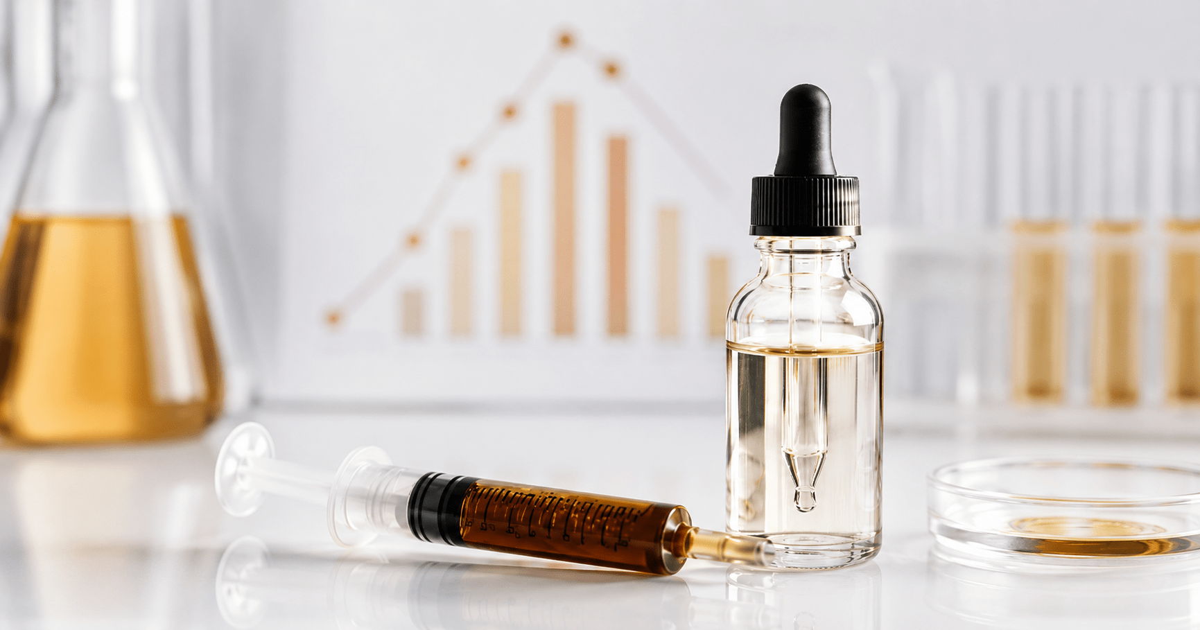 RSO dosing syringe with MCT carrier oil dropper bottle on laboratory surface with bioavailability chart